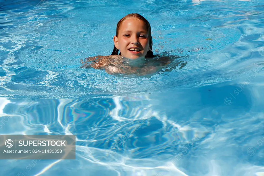 A 10-year old girl swimming in a swimming pool.