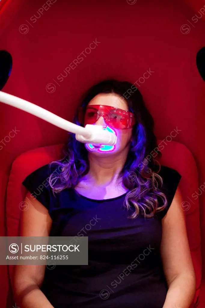 Reportage in a smile bar in Paris, France. Teeth whitening involves applying a whitening paste using a special mouthpiece, then exposing the teeth to ...