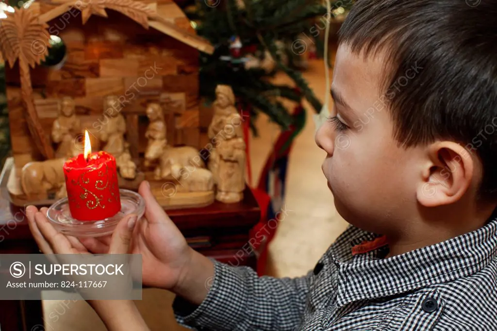 6_year_old boy holding a Christmas candle