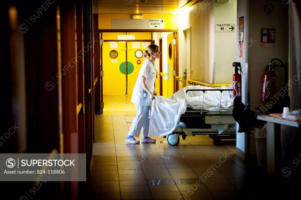 Reportage at night in the A&E department of Robert Ballanger general hospital, France. A nurse moves a patient.
