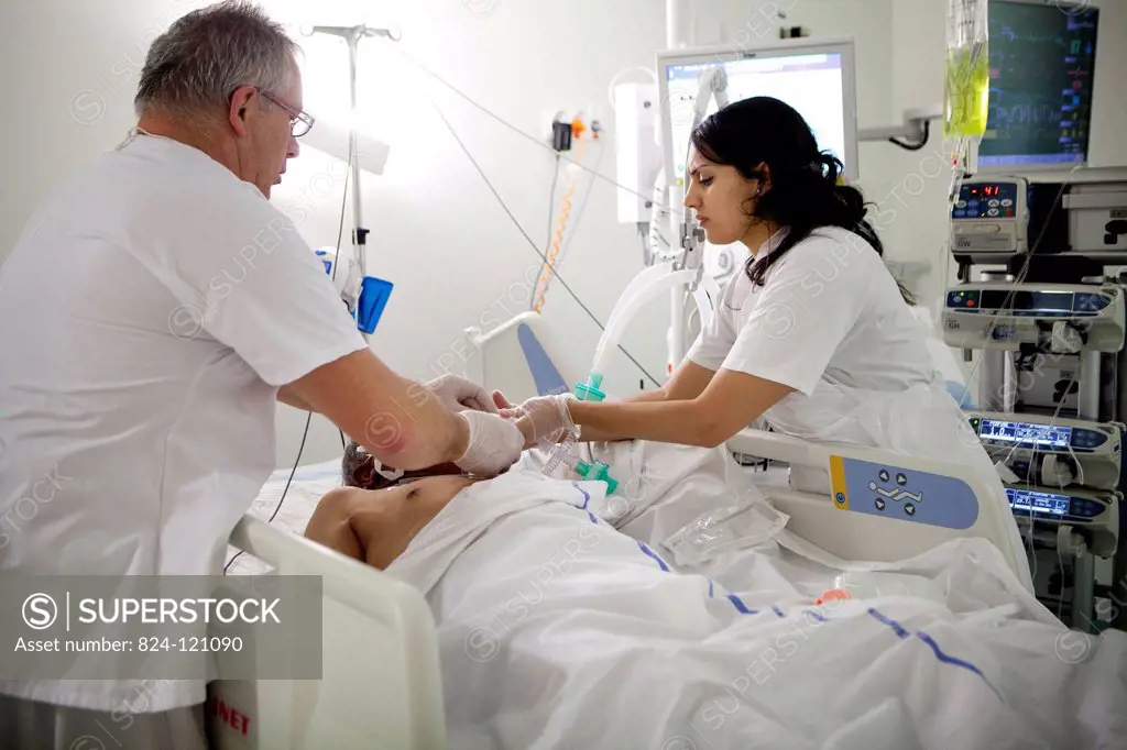 Reportage in Robert Ballanger hospital's Intensive Care Unit in France. A nursing auxiliary and a nurse look after a patient.