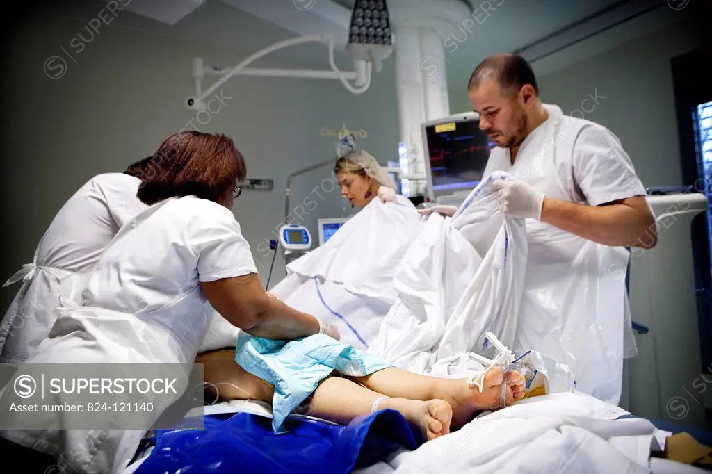 Reportage in Robert Ballanger hospital's Intensive Care Unit in France. A nurse, two nursing auxiliaries and a doctor turn a patient over.