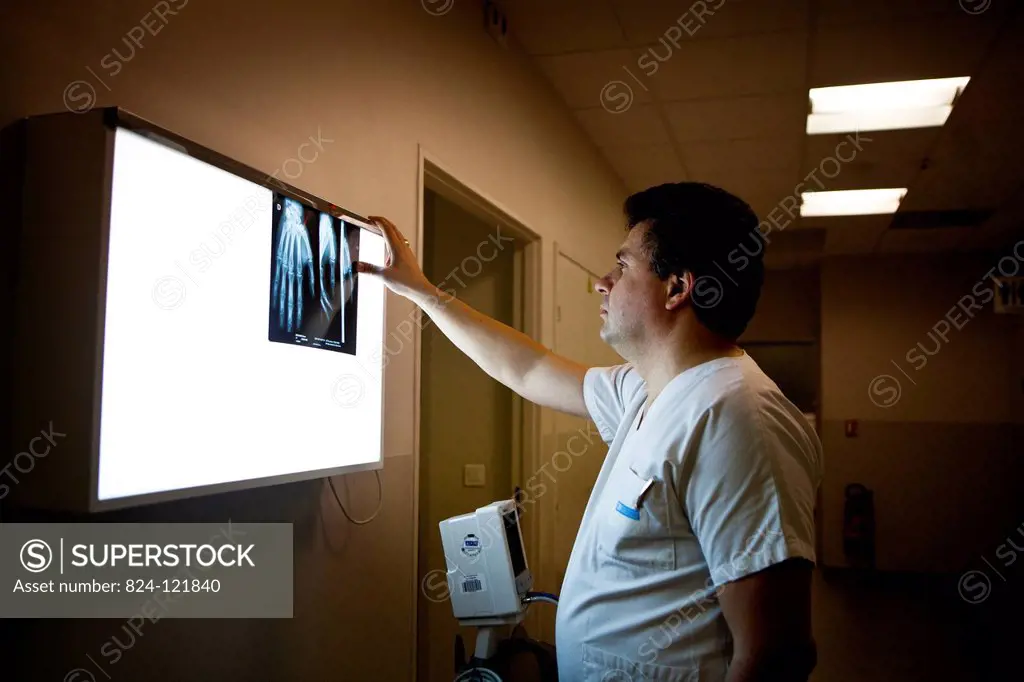 Reportage in A&E at Diaconesses Croix Saint Simon hospital in Paris, France. A doctor examining an x-ray of a hand.