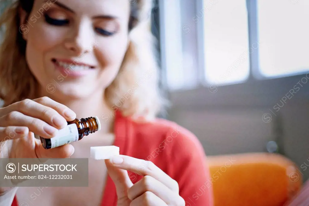 Woman pouring essential oil on a sugar.