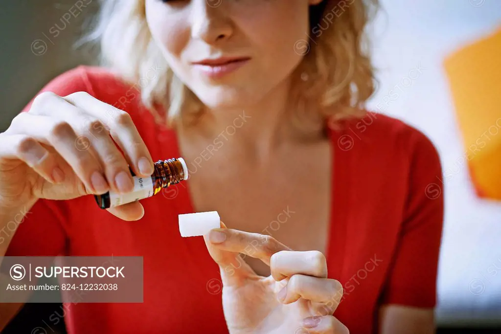 Woman pouring essential oil on a sugar.