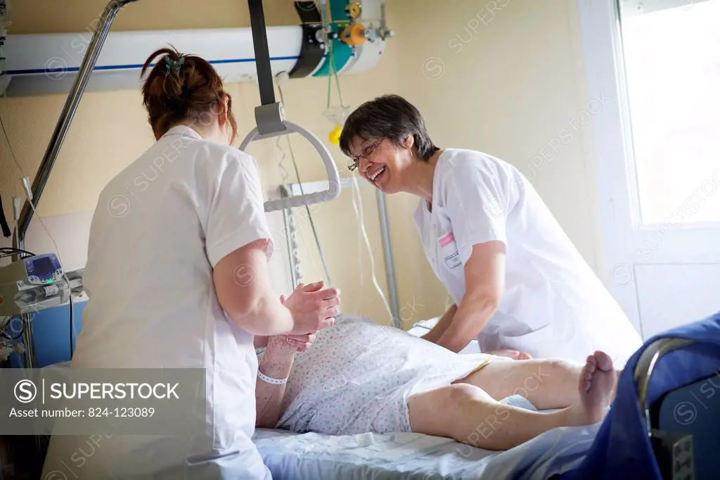 Reportage in Bligny hospital palliative care unit, Briis sous Forges, France. A nurse and auxiliary nurse chat to a patient.
