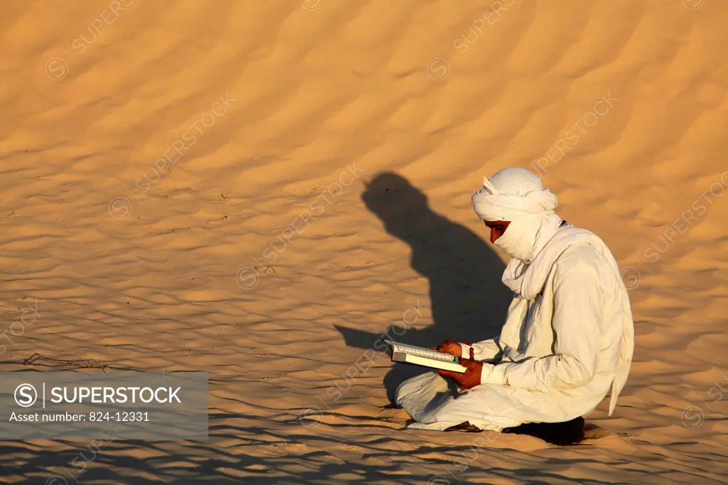 Beduin reading the Kuran in the Sahara.