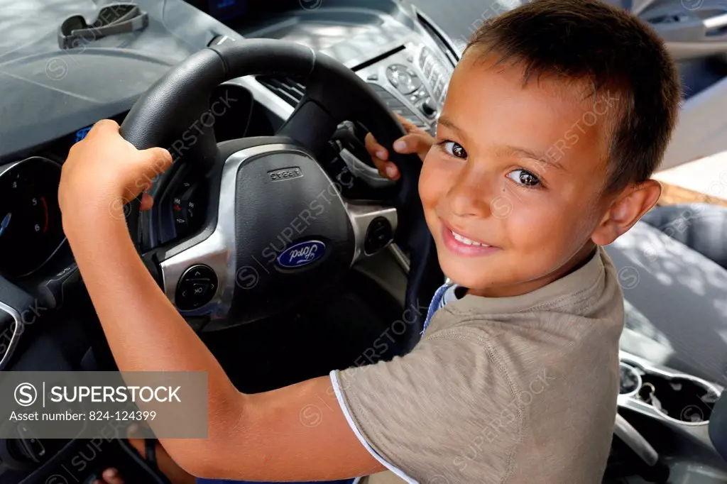 6-year-old boy pretending to drive a car