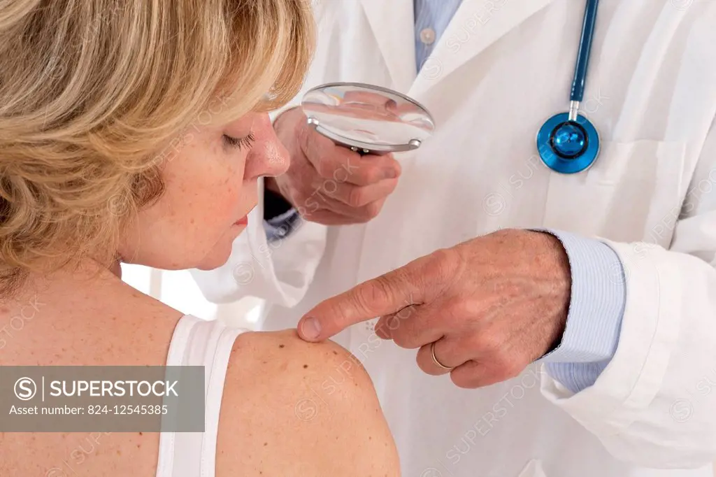 Dermatologist examining patient's moles.