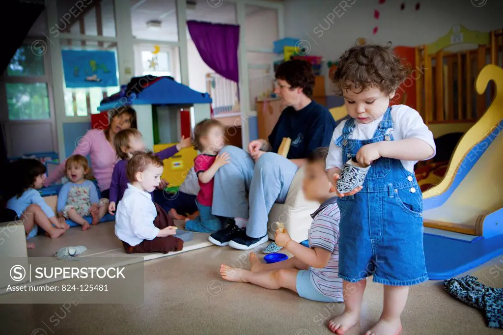 Reportage in a community nursery in Paris, France. Childcare assistant. The images from this series must only be used to illustrate articles about nur...