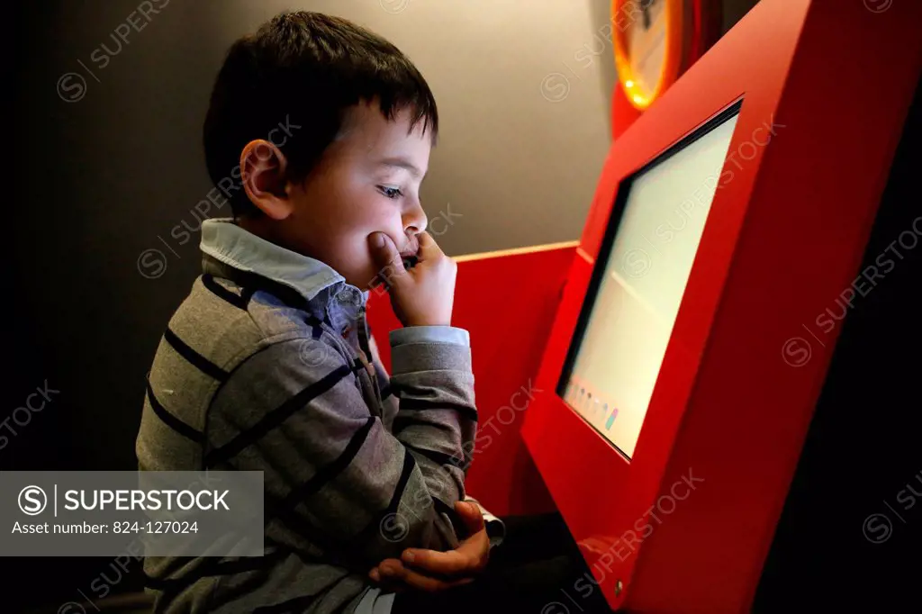 Boy playing with a computer at la Cité des Sciences, Paris