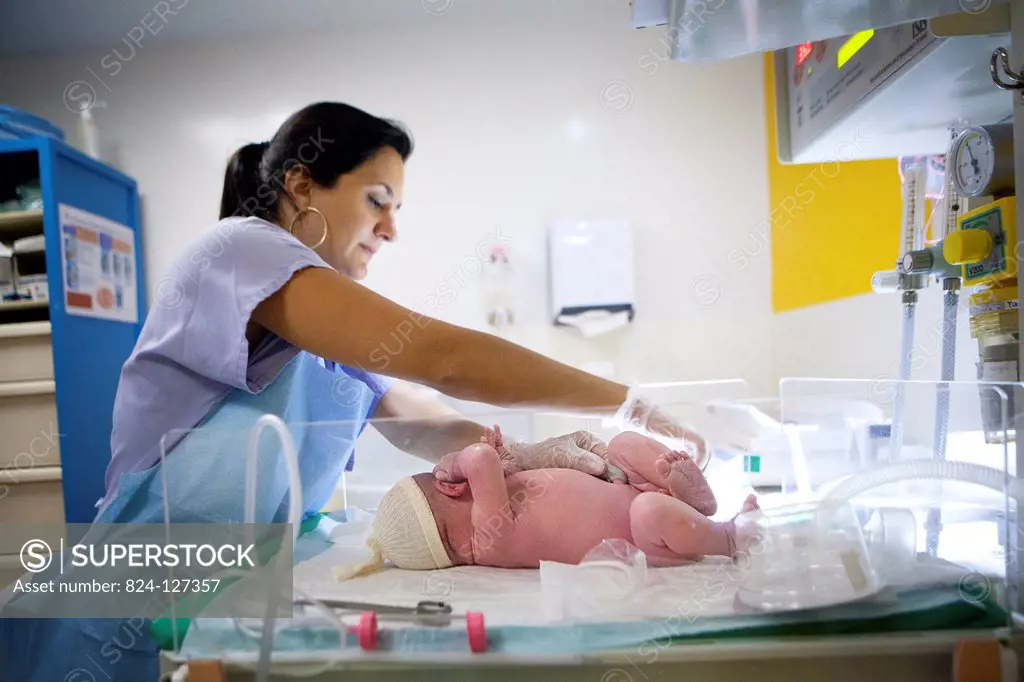 Reportage at the maternity clinic. The pediatric nurse examines Lwan a few minutes after the birth.