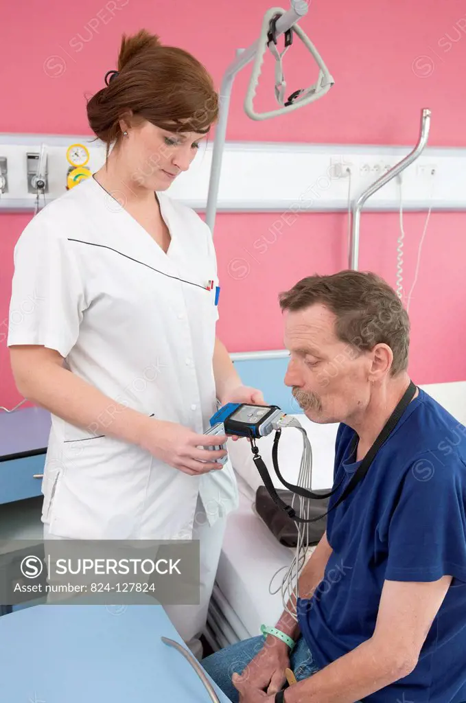 Reportage in the multidisciplinary care service in Saint-Vincent de Paul hospital in Lille, France. An auxiliary nurse changes the batteries in a tele...