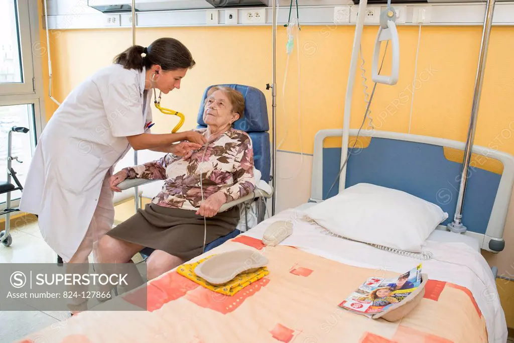 Reportage in the Follow-up Care and Rehabilitation service of Saint-Philibert hospital in Lille, France. A doctor examines a patient in her hospital r...