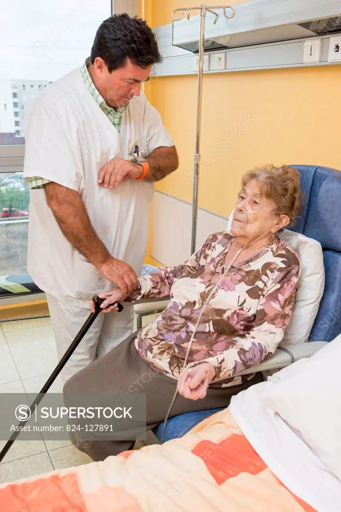 Reportage in the Follow-up Care and Rehabilitation service of Saint-Philibert hospital in Lille, France. A physiotherapist checks a patients pulse af...