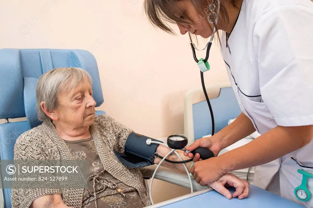 Reportage in the Follow-up Care and Rehabilitation service of Saint-Philibert hospital in Lille, France. A nurse takes a patient's blood pressure in h...