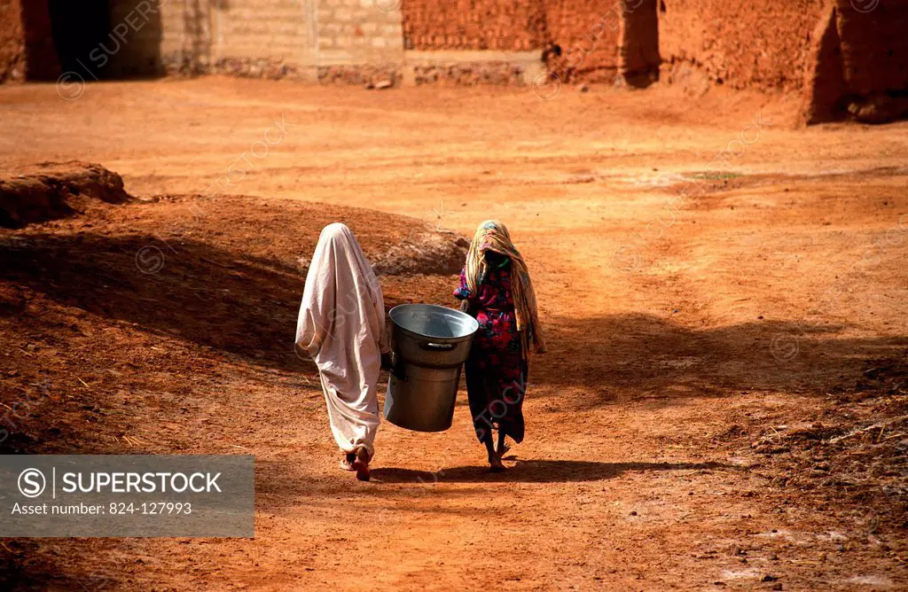 Tuareg population of Timimoun in Algeria. Two women walking home from the market.