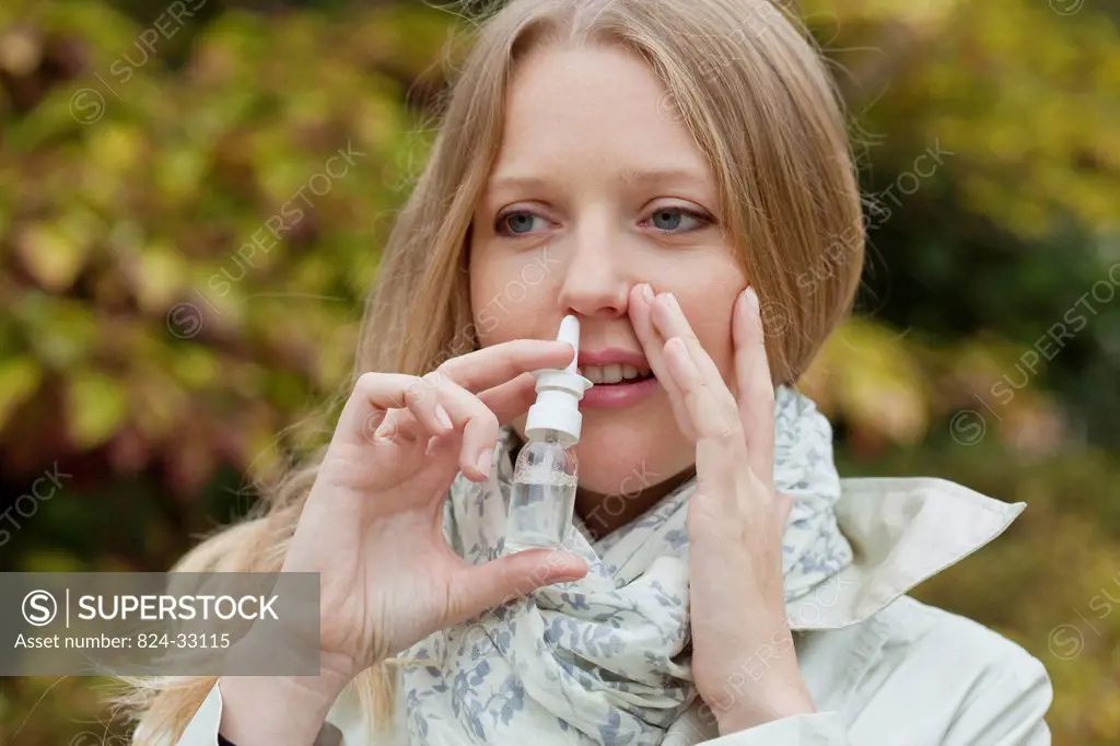 WOMAN USING NOSE SPRAY