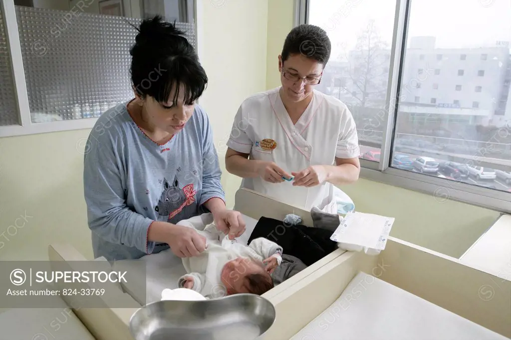 Photo essay at the maternity of Rouen hospital, France. Nursery. Child care aid explains to the young mother how to make the daily care and the toilet...