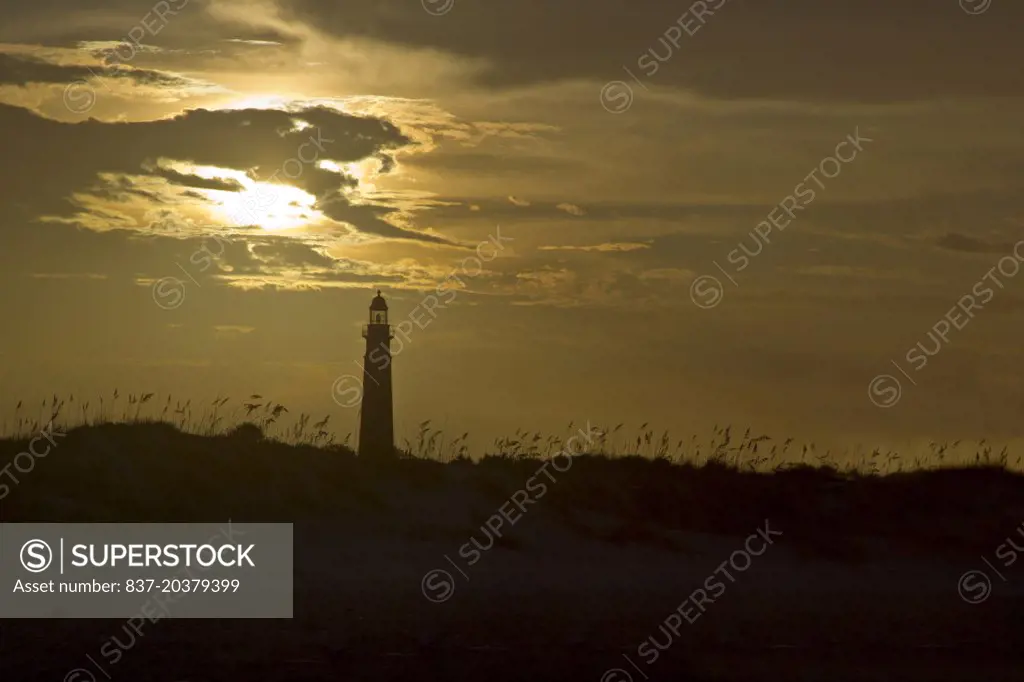 A SCENIC showing the Ponce Inlet, Florida lighthouse viewed from the beach as clouds block most of the afternoon sunlight