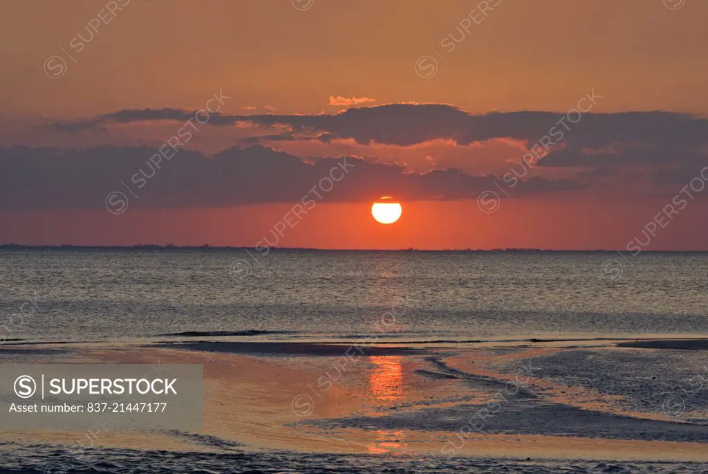 dramatic red sky as the sun sets near estero lagoon