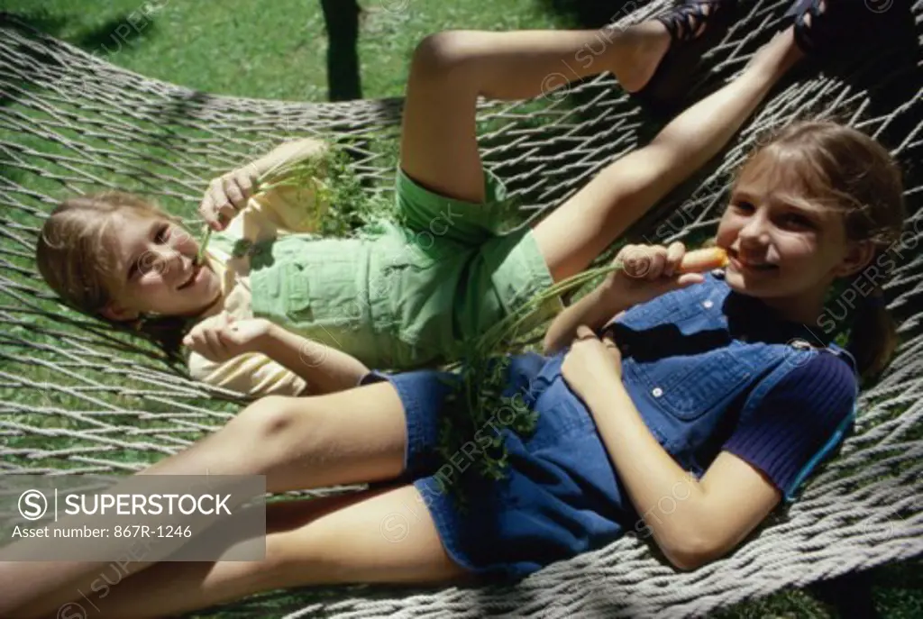 Portrait of two girls lying on a hammock