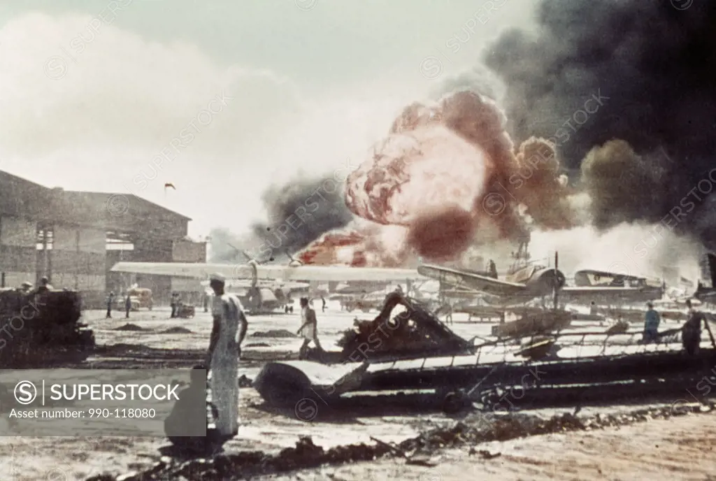 Sailors surrounded by wrecked planes at the Ford Island Naval Air Station watch as the USS Shaw explodes Pearl Harbor, Hawaii, USA December 7, 1941