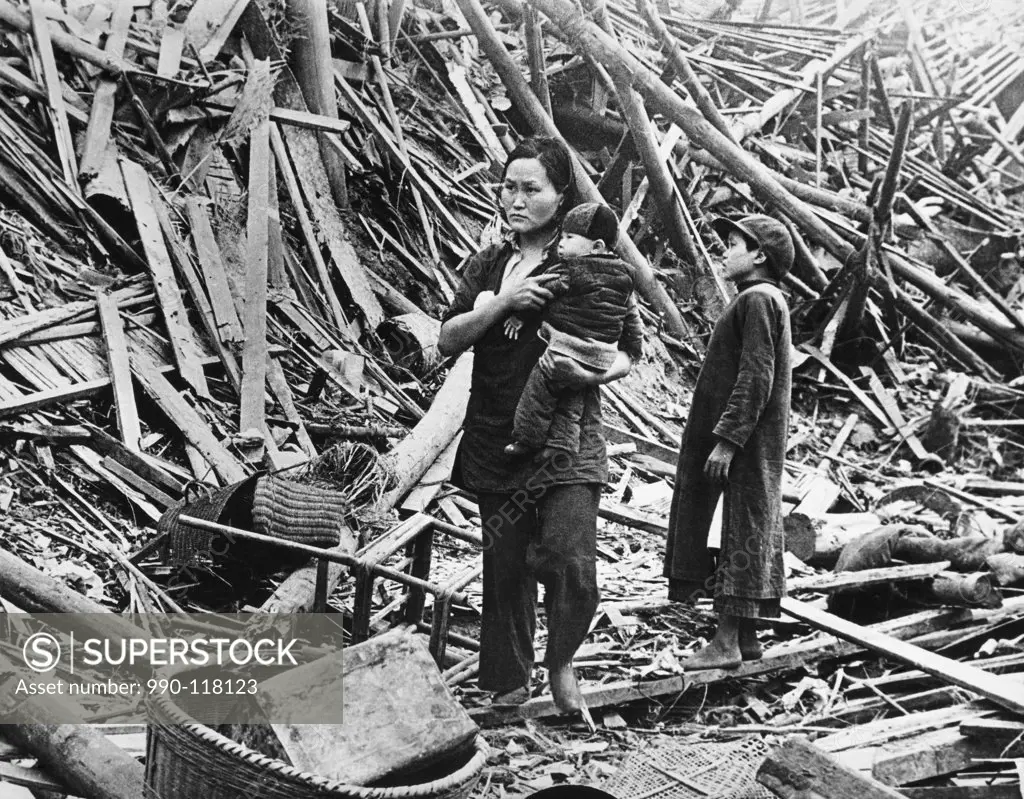 Mother standing with her two children among the air raid ruins, Chongqing, China