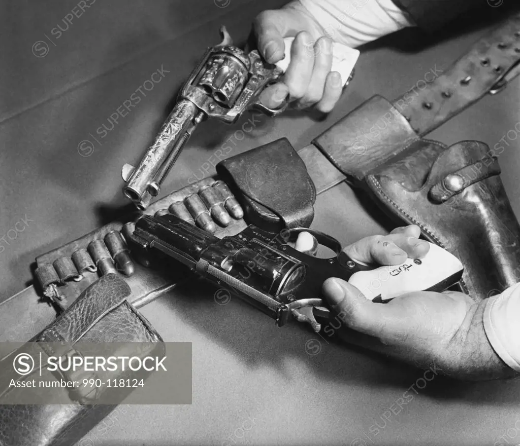 Close-up of man's hands holding a .45 Caliber Colt Army Revolver with a Smith and Wesson .357 Magnum Revolver