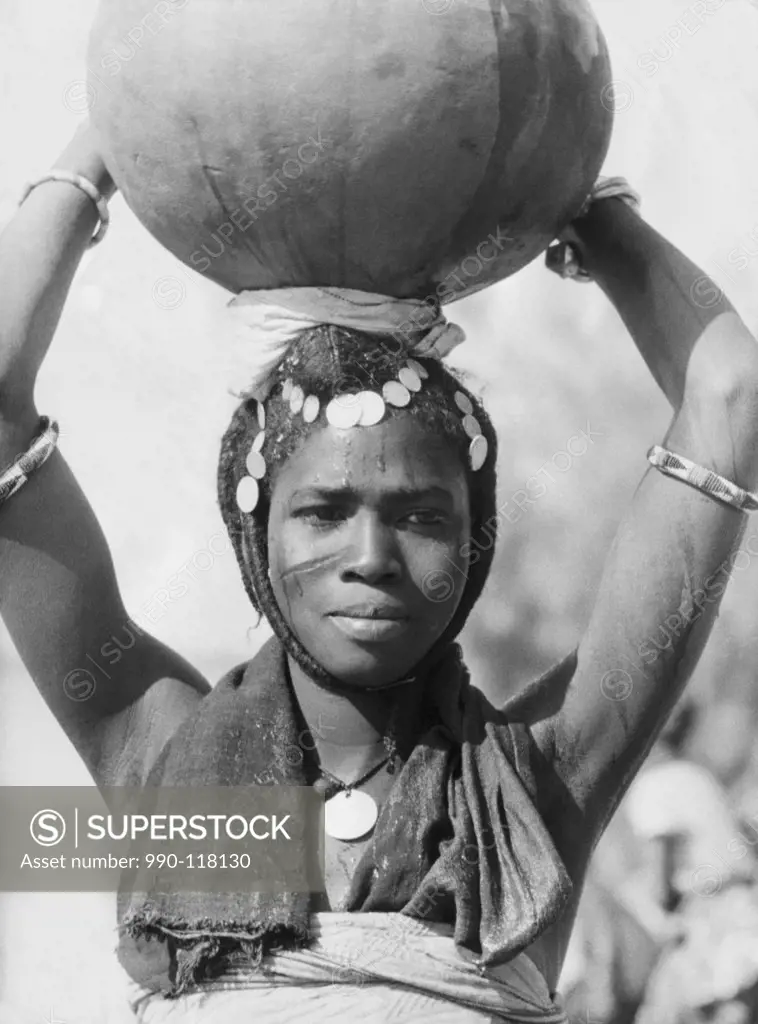 Close-up of a young woman carrying a pitcher on her head, Dakar, Senegal