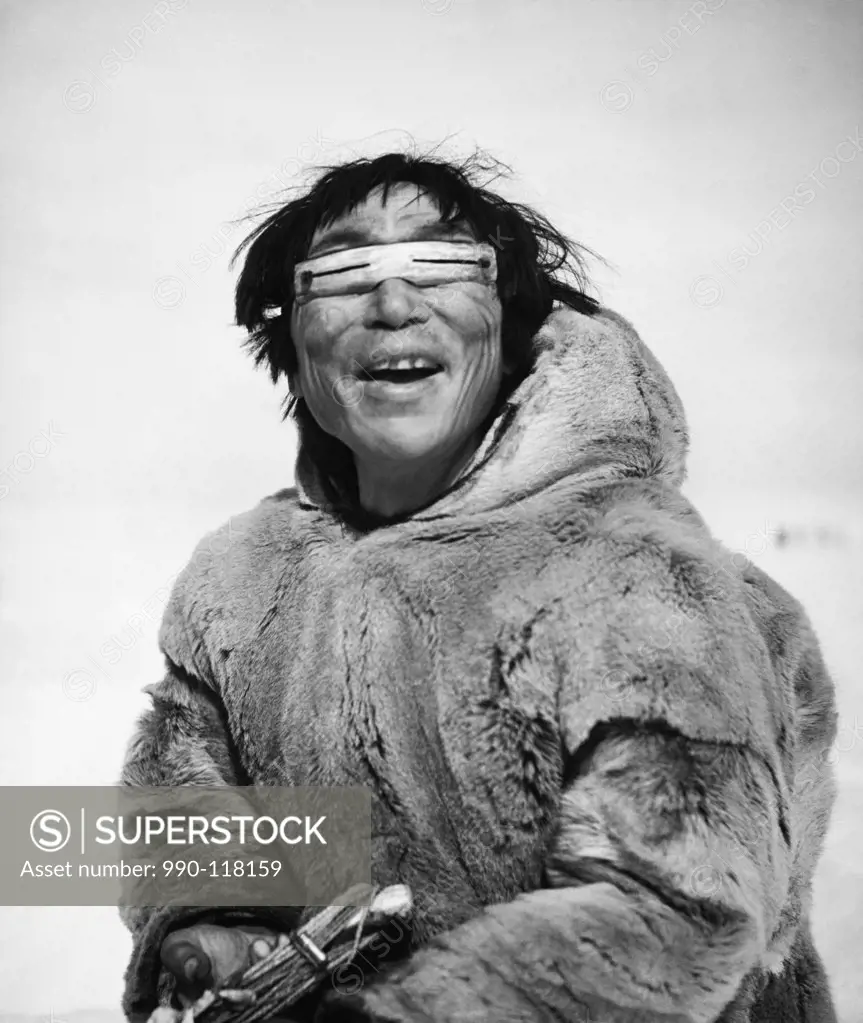 Eskimo man wearing wooden goggles and smiling, Alaska, USA