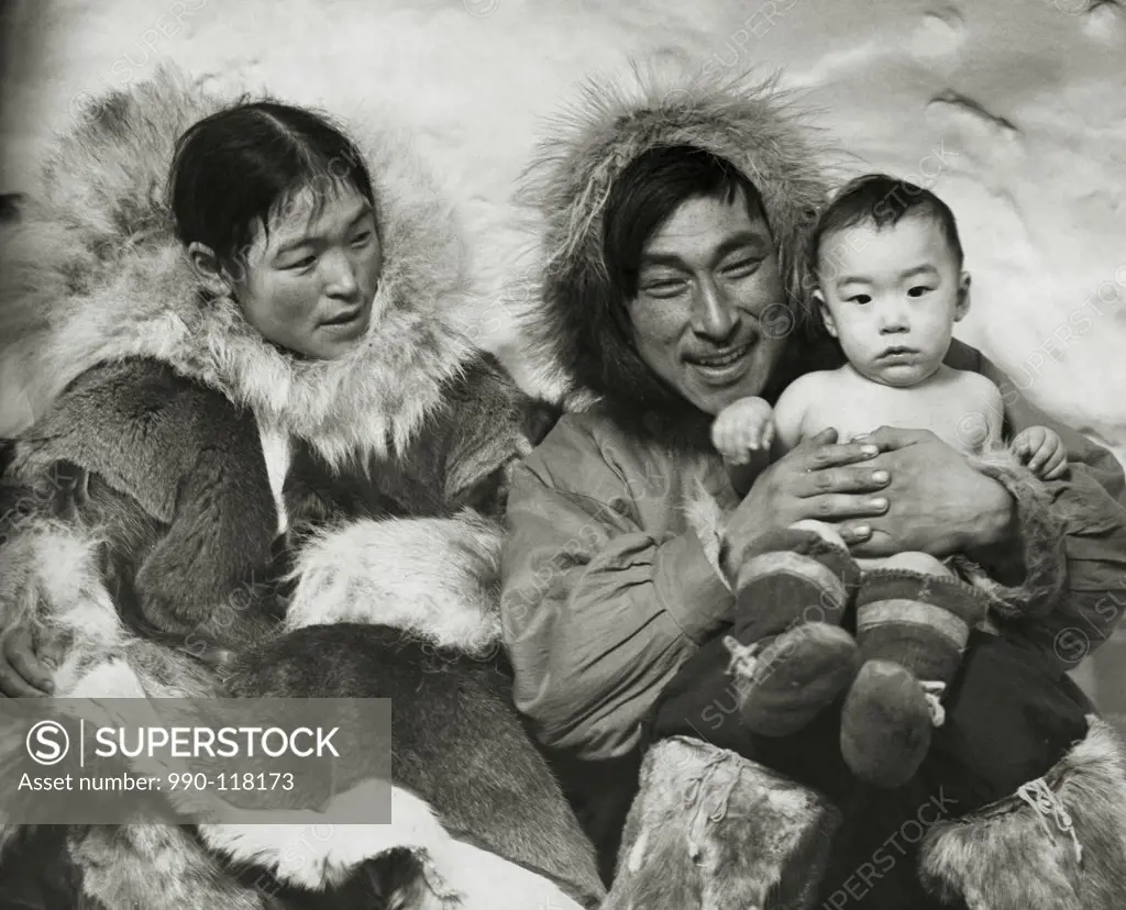 Eskimo couple sitting with their son