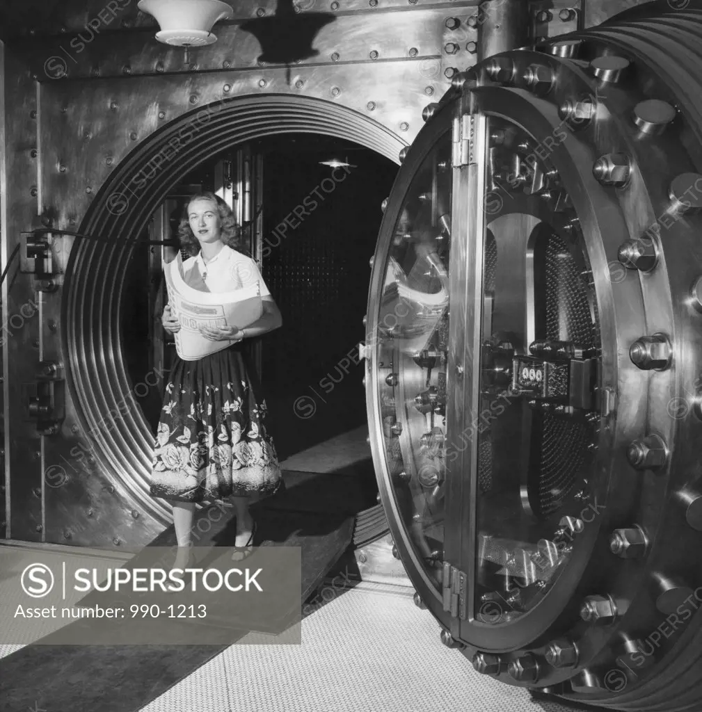 Mid adult woman coming out from a bank vault