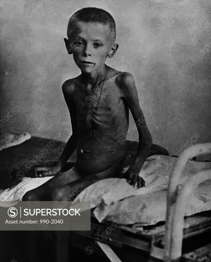Polish victim of Nazism sitting on the bed in a concentration camp