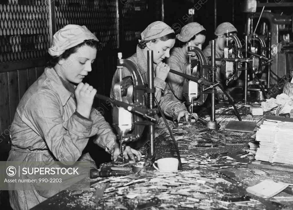 Side profile of female workers working in a factory, England