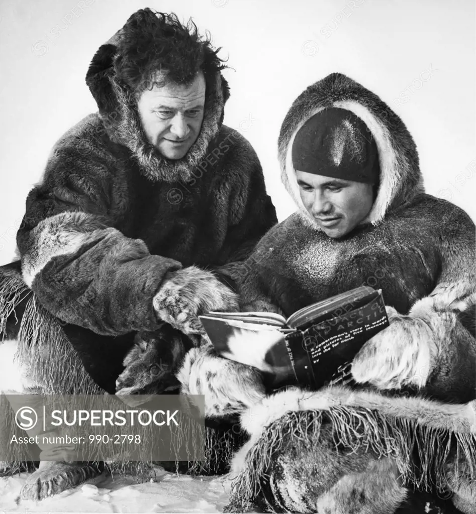 Arctic, two men in furs sitting and reading book