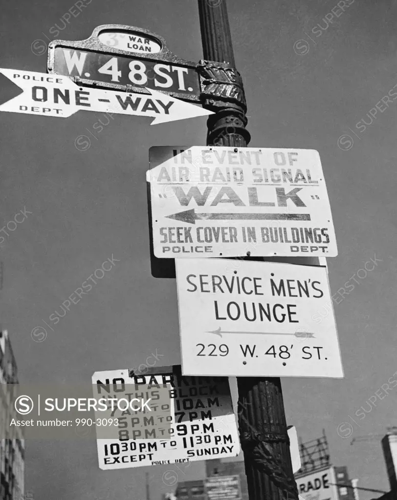 Low angle view of street name signs and signs on a pole, New York city, New York, USA, C. 1940