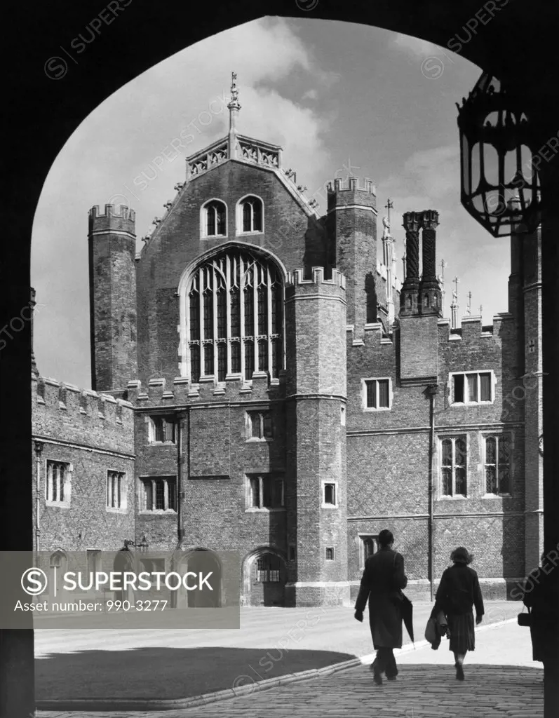 Two people walking in front of a building, Great Hall, Hampton Court Palace, Middlesex, England