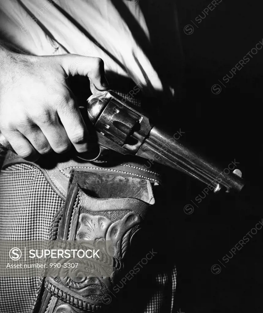 Mid section view of a man holding a revolver