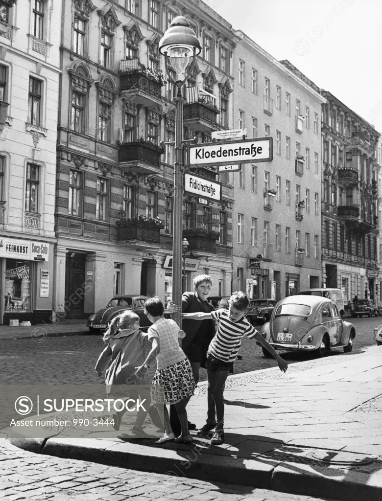 Boys and girls playing around a lamppost, Kreuzberg, Berlin, Germany