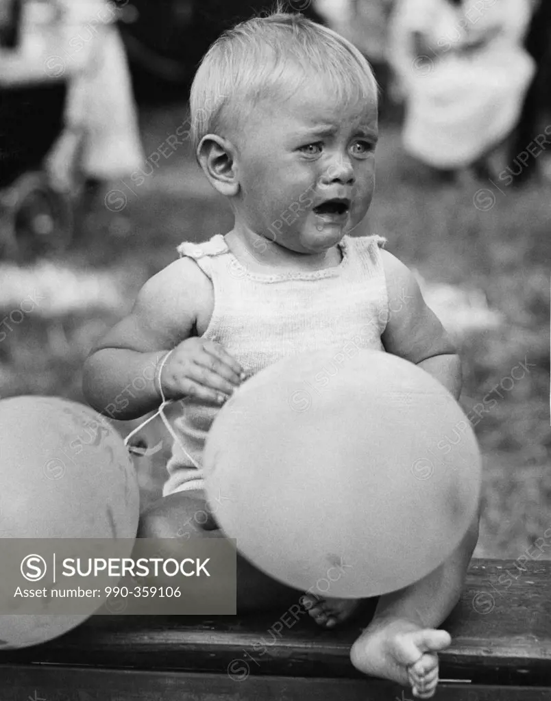 Crying baby girl with balloons