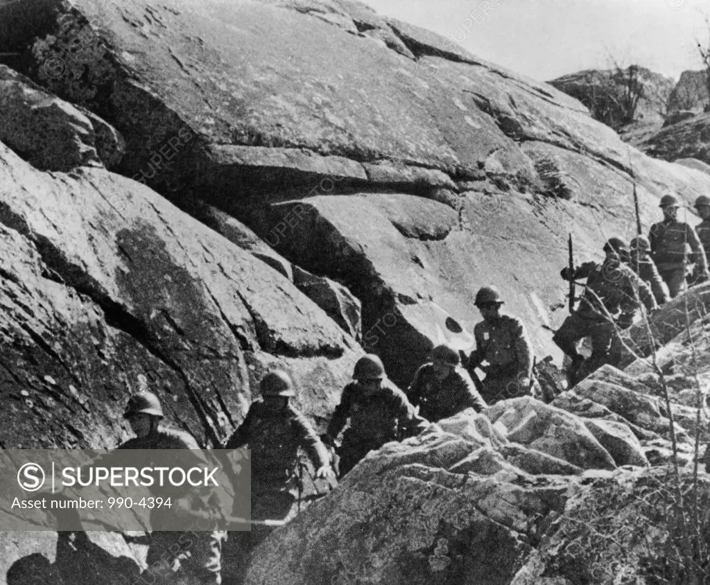 Soldiers of the Japanese military passing by rocks, Manchuria, China, 1932