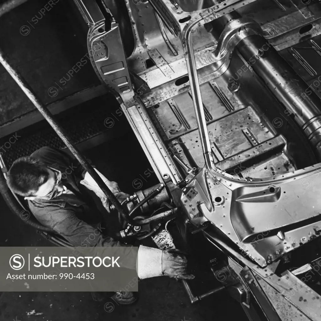 High angle view of male worker working in car assembly plant