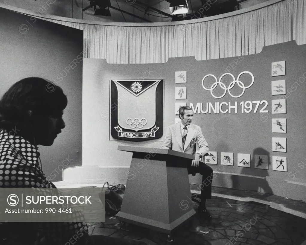 Sportscaster sitting behind a podium, Chris Schenkel, Summer Olympic Games, Munich, Germany, 1972